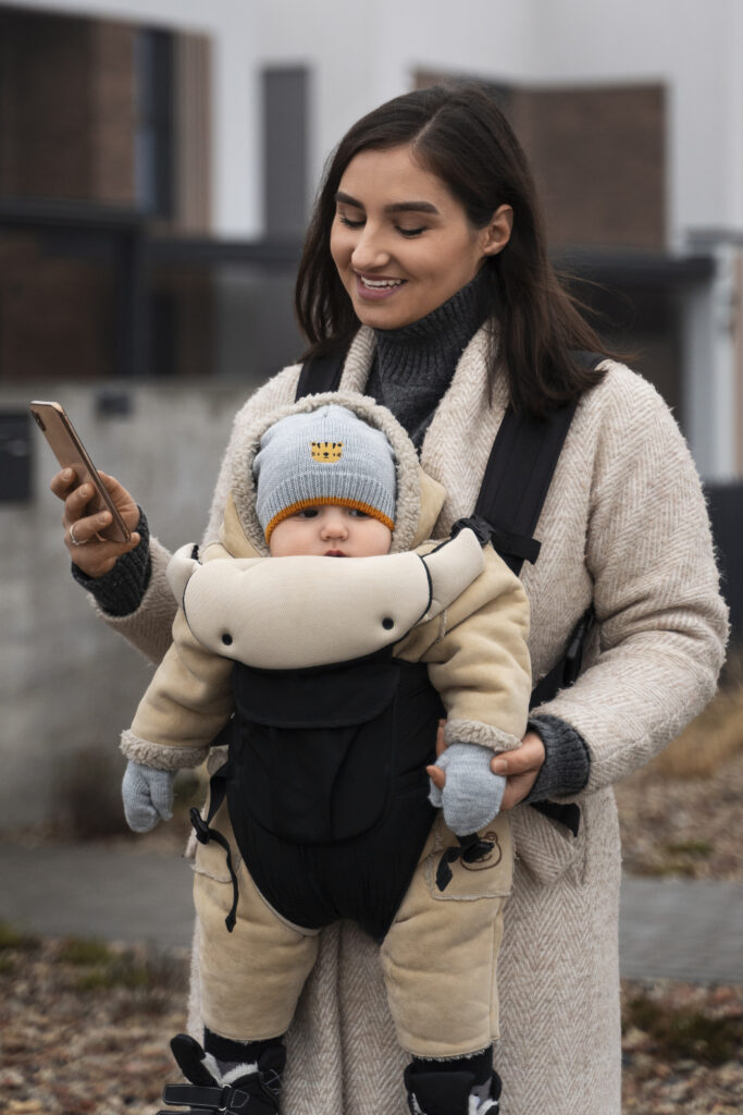medium shot woman holding baby carrier