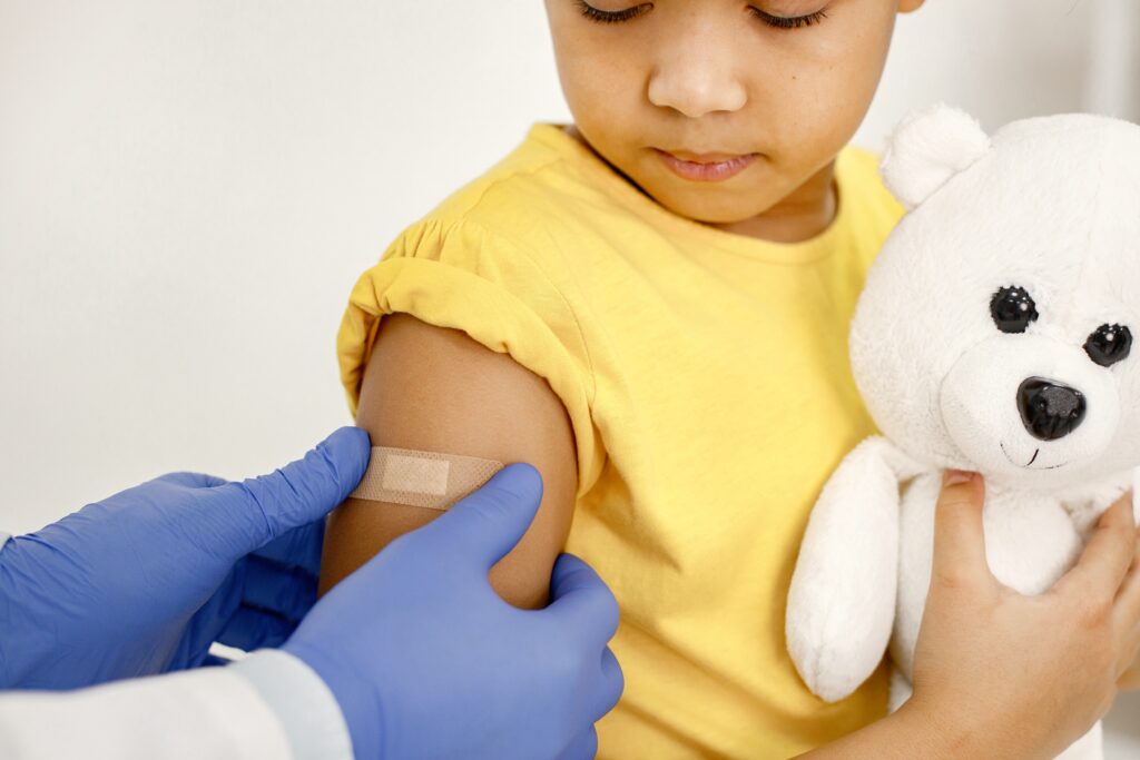 doctor stick bandaid girl s shoulder after vaccination